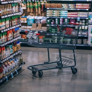 Empty shopping trolley in a supermarket aisle