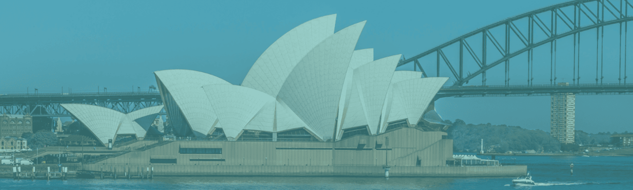 View of the Sydney Opera House with the Sydney Harbour Bridge in the background, seen from across the water on a clear day.