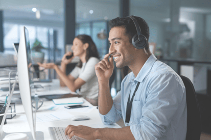 Sales professionals on headsets working at their computers