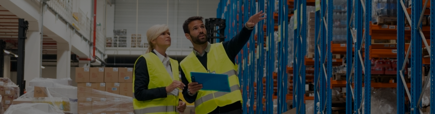 Woman and man in hi vis jackets in a warehouse