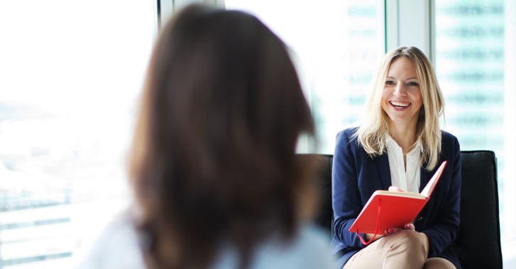 Woman smiling and interviewing another woman