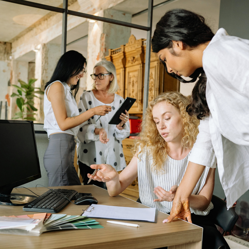 Four women talking around an office desk