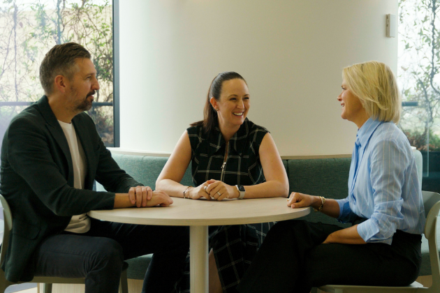 three professionals sitting around a table talking