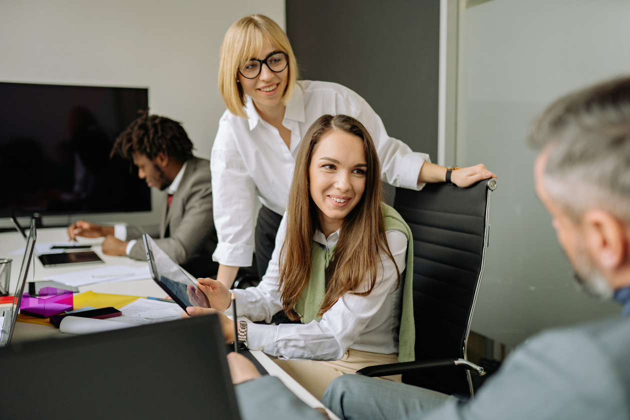 two professional women talking to man in office setting