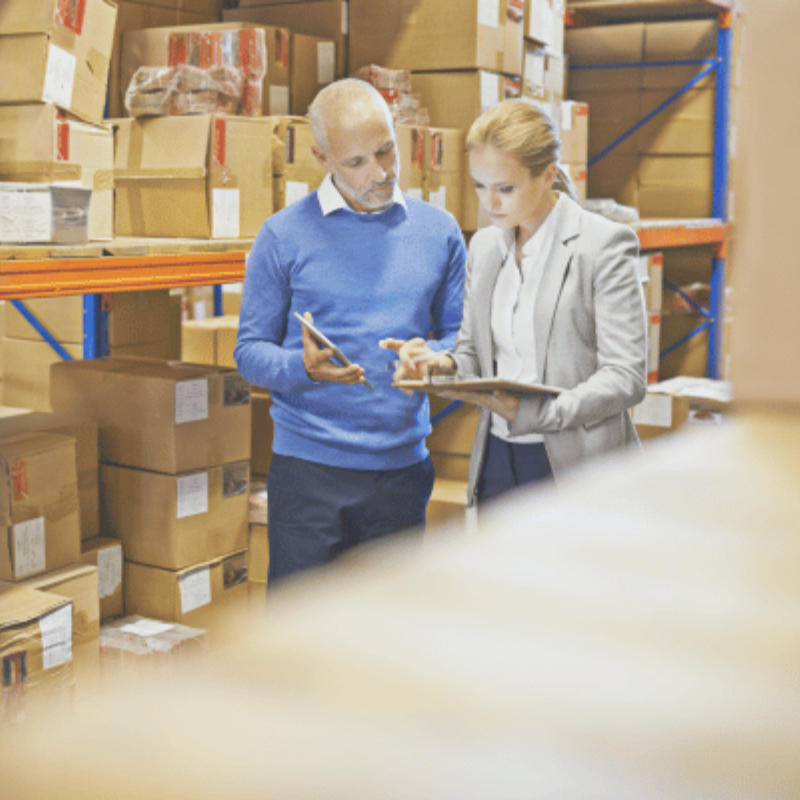 man and woman in warehouse reviewing document together