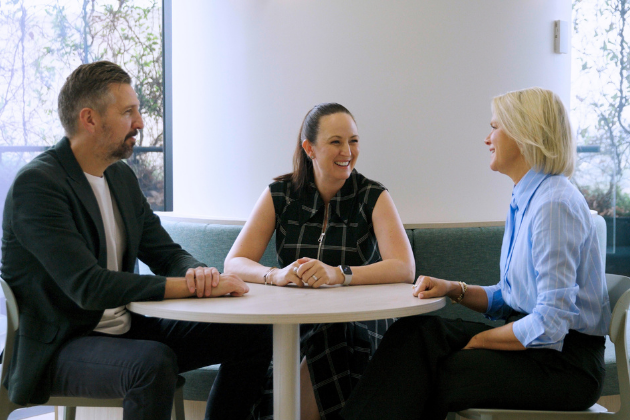 three professionals sitting around a table talking