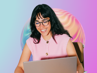 Woman smiling at her laptop with a colourful backrgound