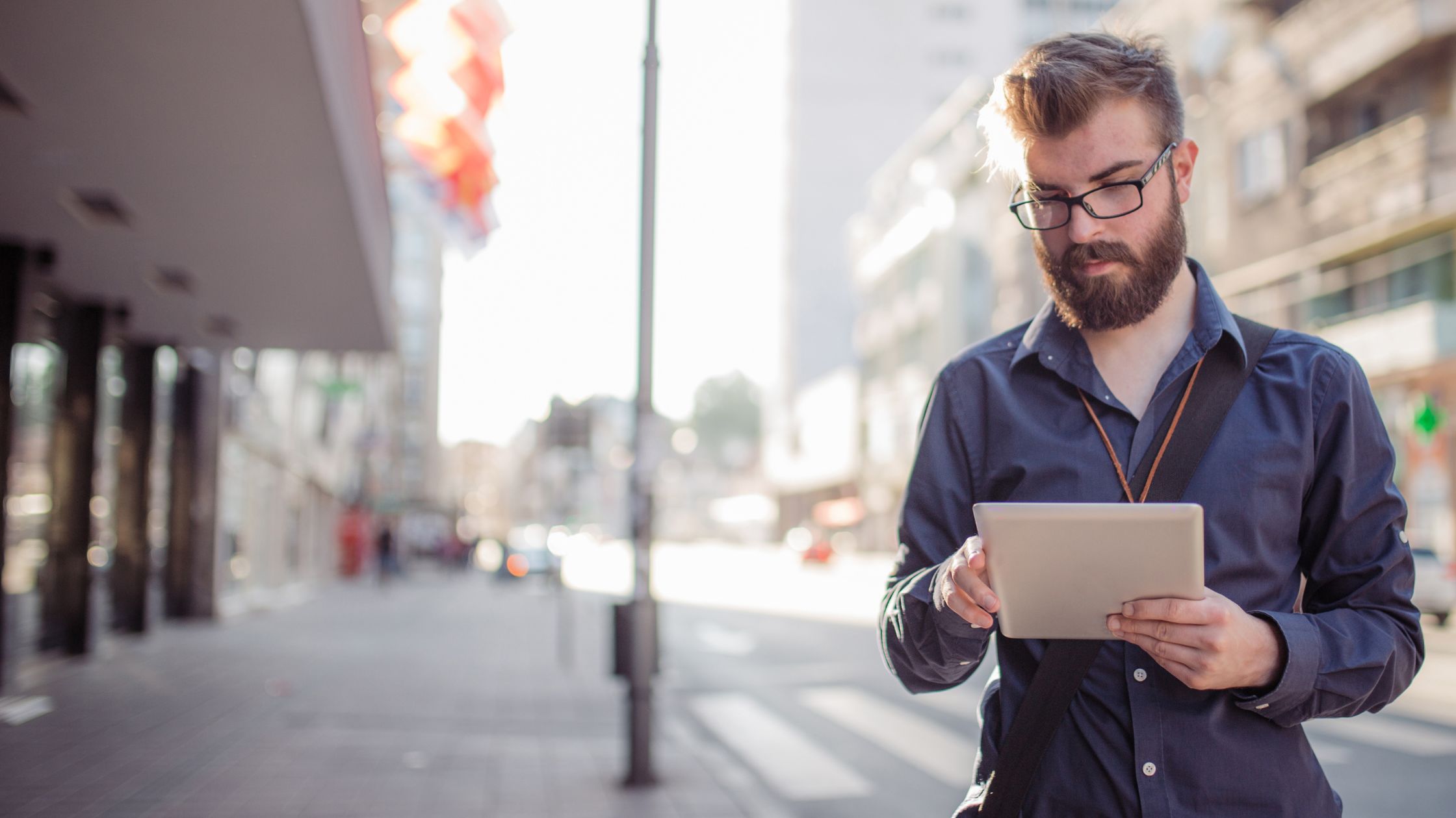 image of a man in the street looking at something on a document