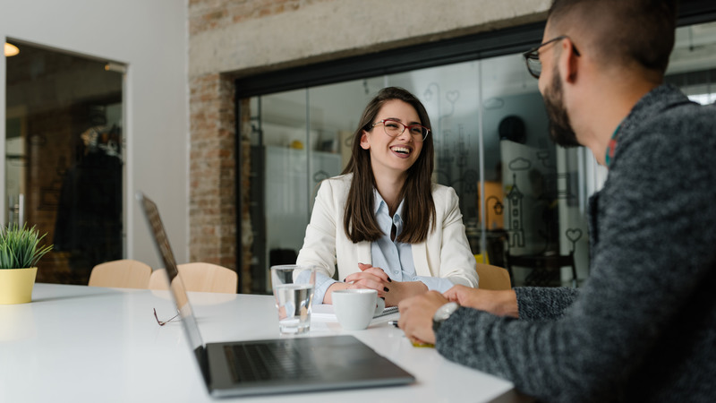 two people laughing at their desk