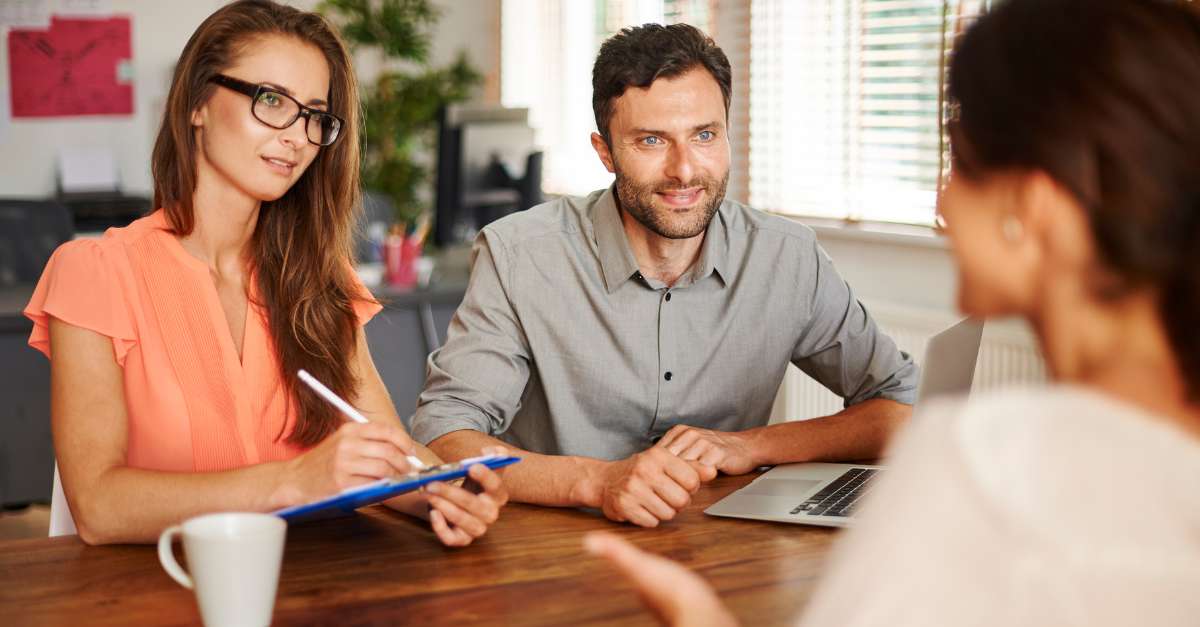 woman being interviewed by 2 people smiling