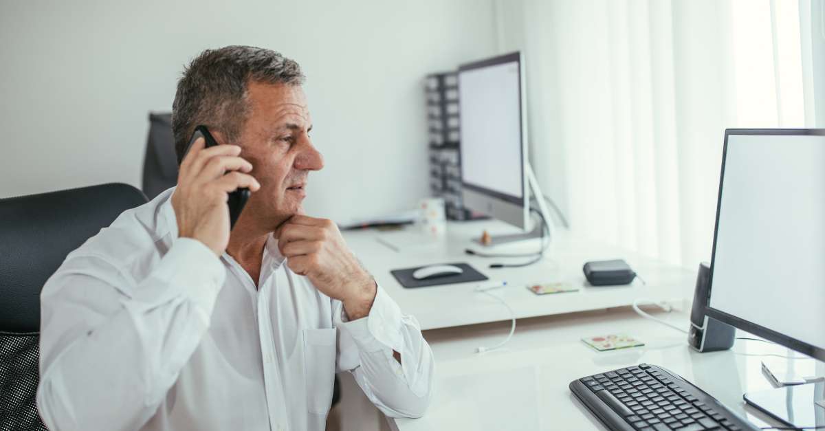 Man on phone looking at computer