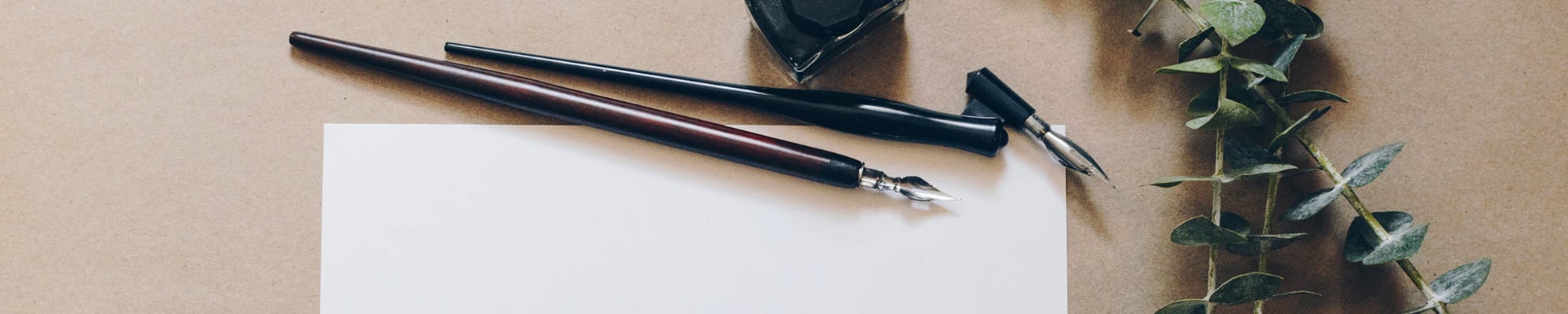image of a white paper with two fountain pens